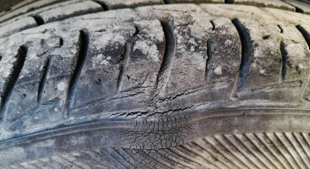 Close-up of a worn tyre with visible cracks and a tyre bulge on the surface